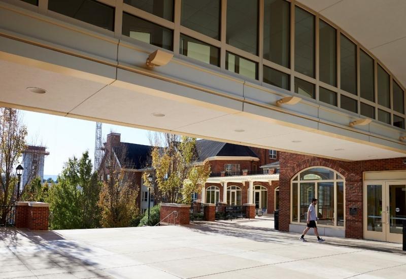 Student Walking in front of building exterior