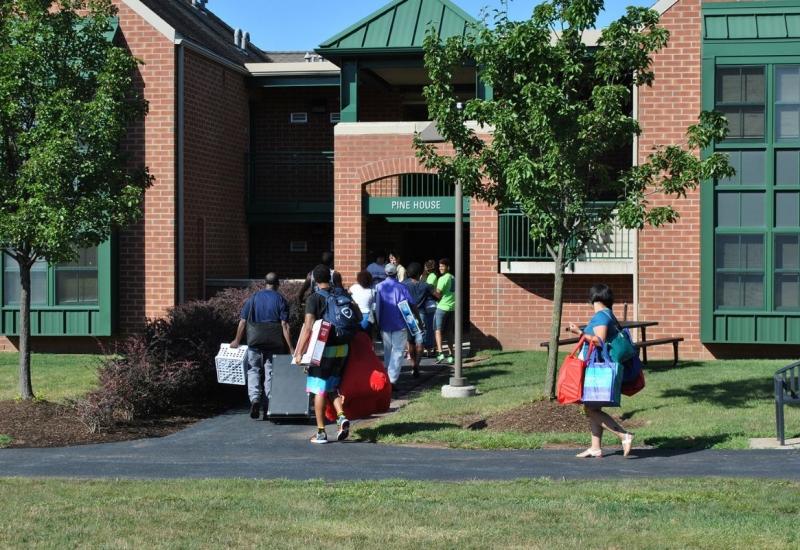 Pine House exterior with students moving in
