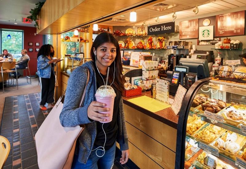 Female standing in front of Higher Grounds checkout counter 
