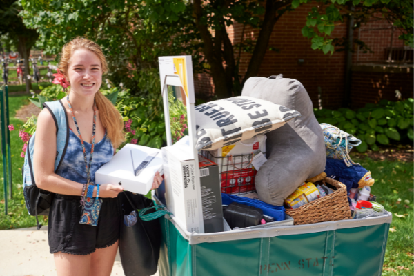 student with a loaded cart of items moving in student with a loaded cart of items moving in