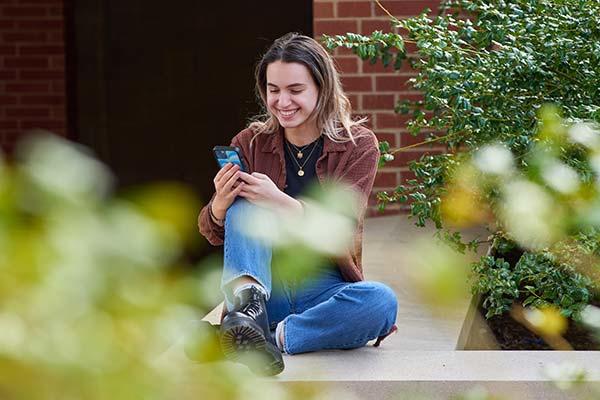 student uses her phone to log in to HFS online contract