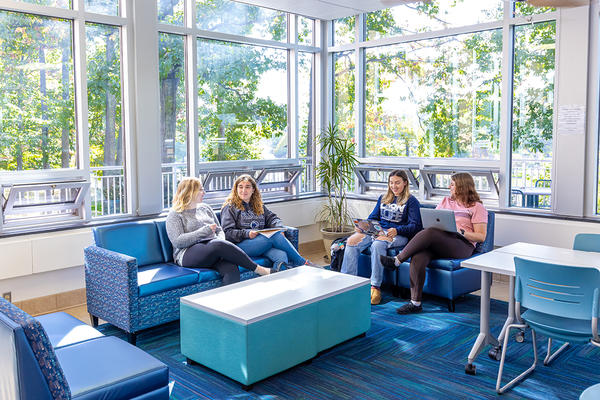 Current students Students visit with one another while seated in the lounge at Oak Hall