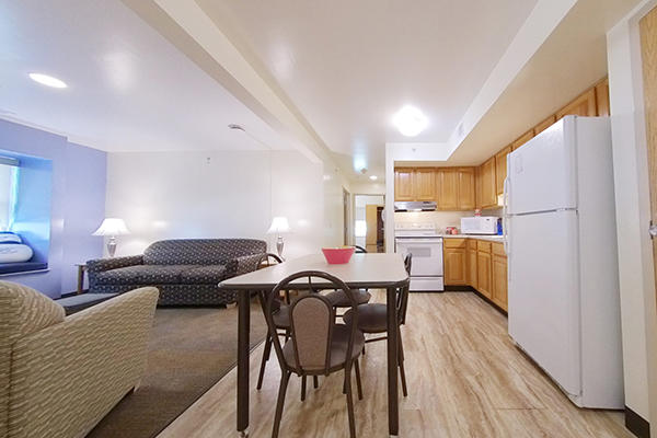 A well-lit apartment with a living room, dining area, and kitchen.