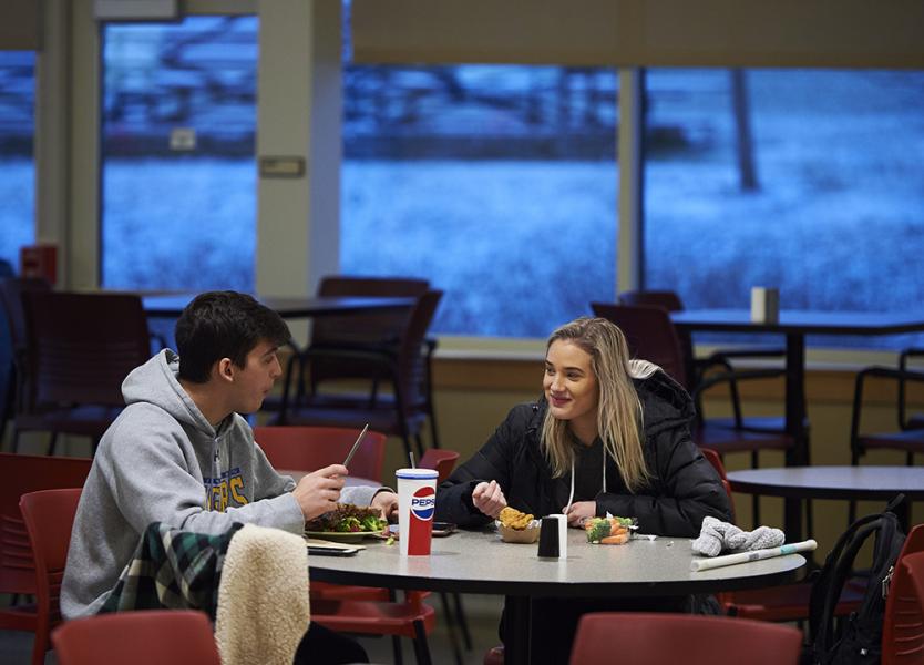 Students sitting at a table eating 
