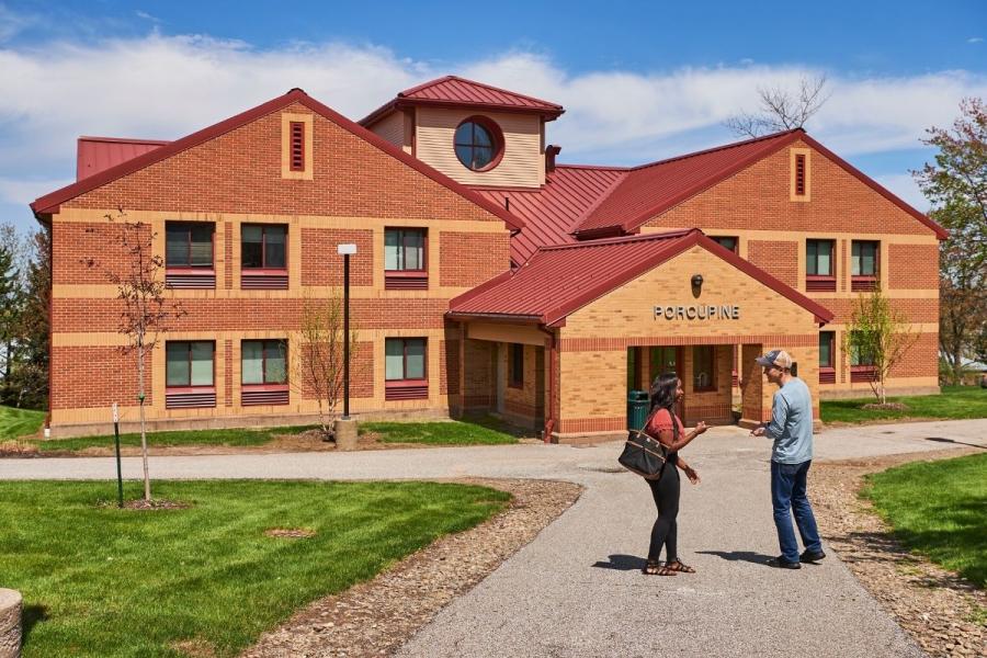 Porcupine Hall Exterior with two students standing in front