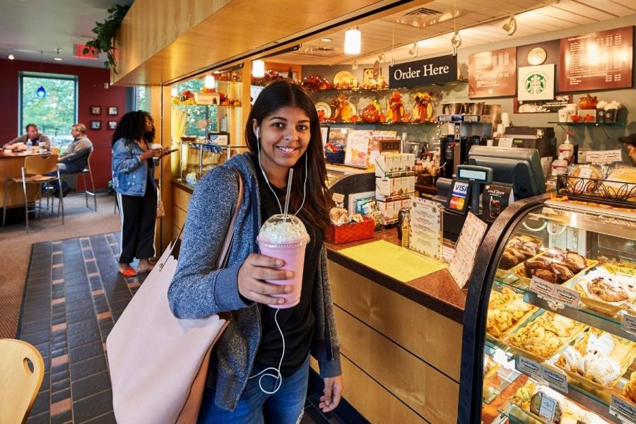 Female standing in front of Higher Grounds checkout counter 