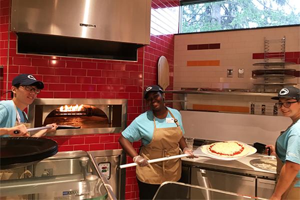 Student employees at the wood-fired pizza oven