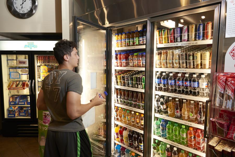Student reaching for a drink from the beverage cooler