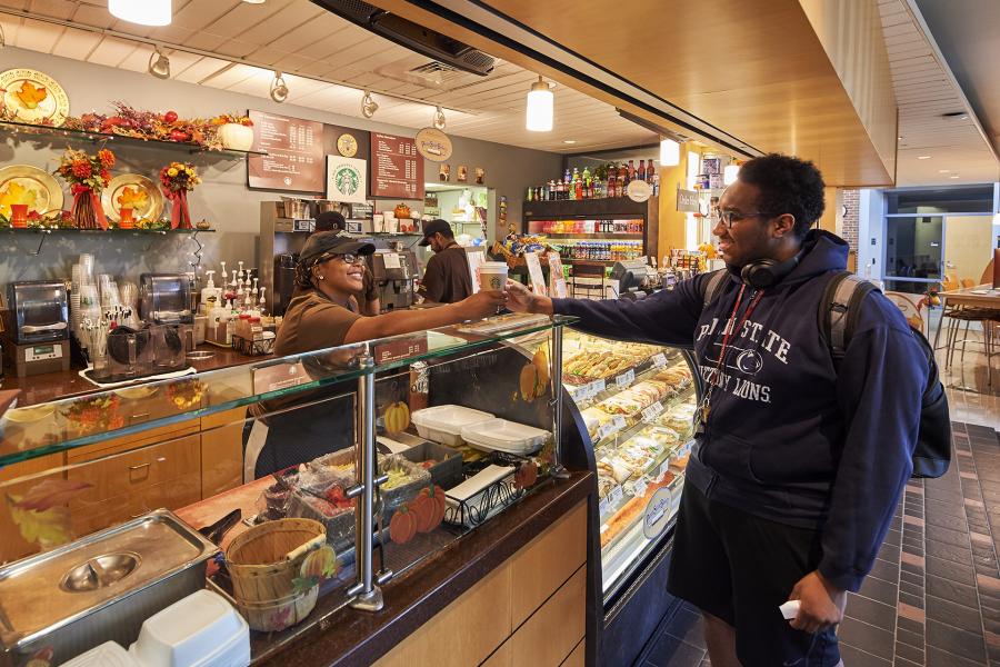 Higher Grounds with student receiving coffee