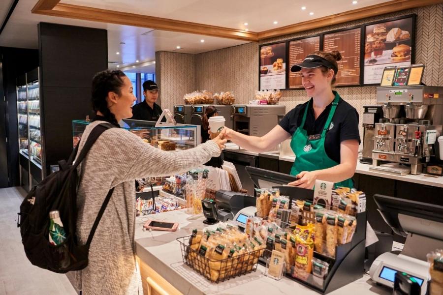 Student picking up drink from Starbucks employee
