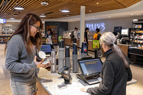 Student uses her mobile phone to pay for a drink