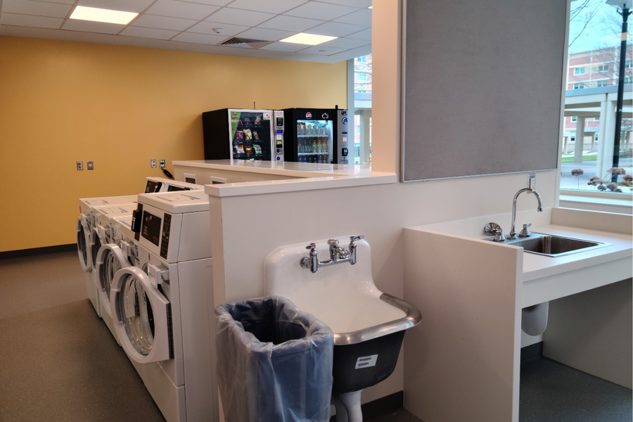 Hastings laundry room that offers several washers, dryers, sink, and vending machines