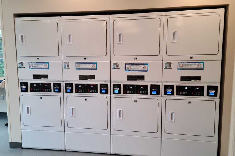 Hastings laundry room that offers several washers, dryers, sink, and vending machines