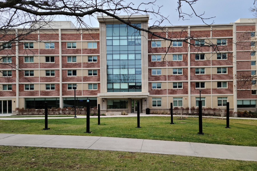 Stone Hall building exterior showing entry way and 4 floors. Hammock grove is shown in front of building entry