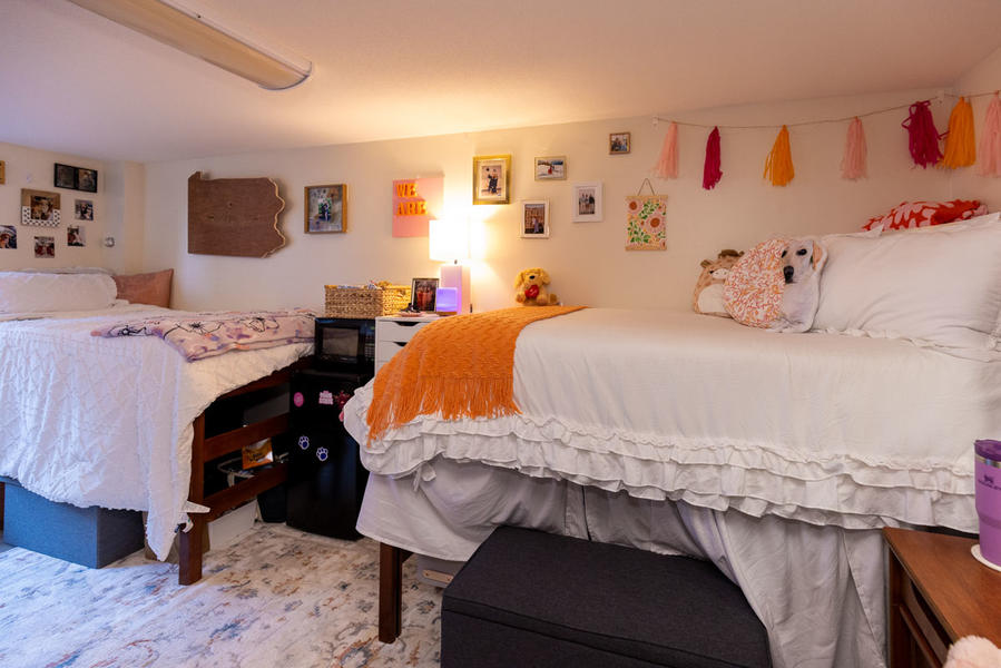 Two dorm beds decorated with orange and blue blankets