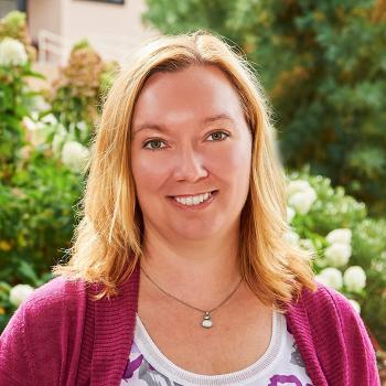 A smiling Linda MacDuff among sunshine and nature