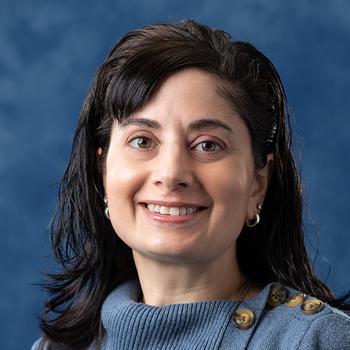 A smiling Maria Umbriac in front of a Penn State blue backdrop