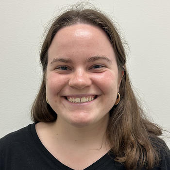 A smiling Claire Perritano in front of a white backdrop
