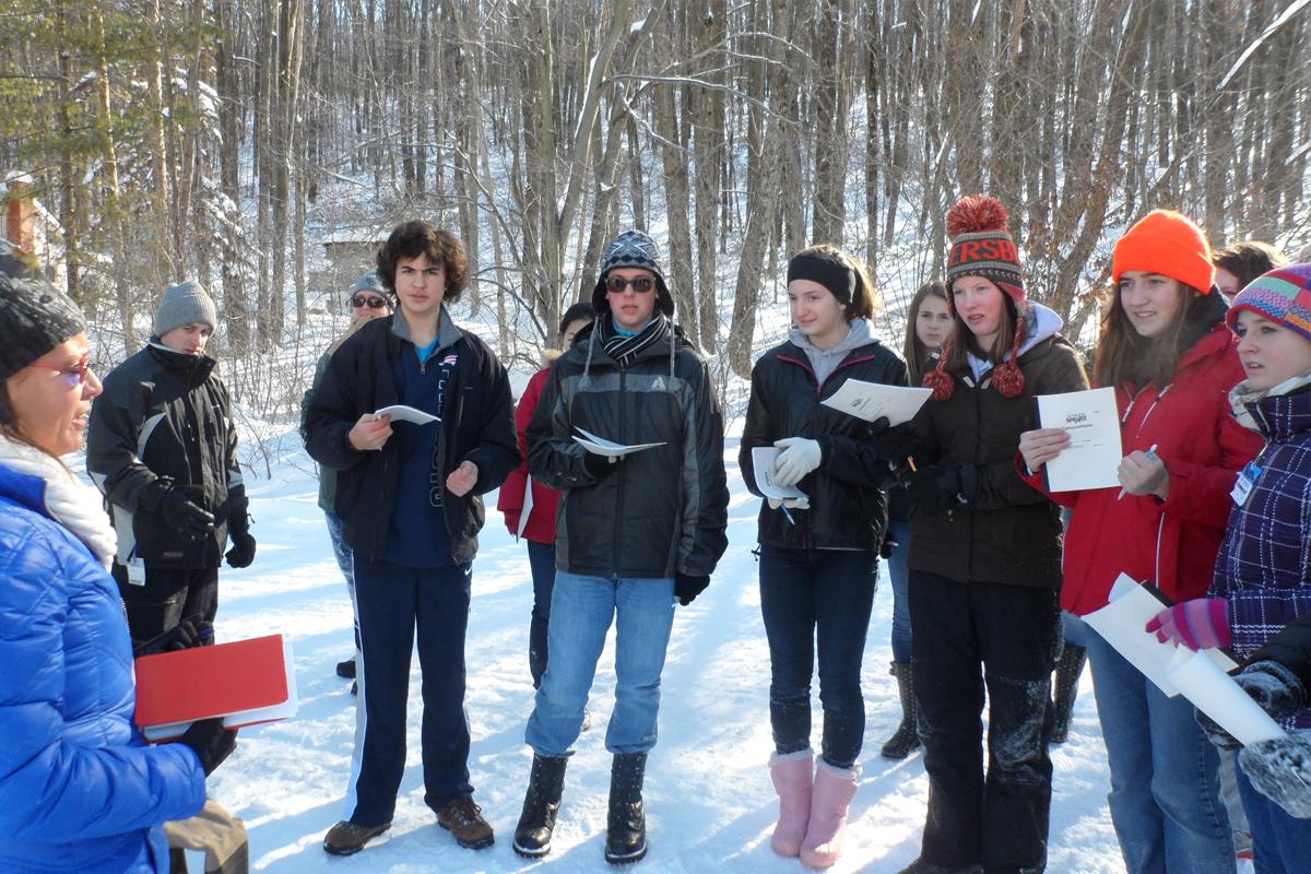 Earth House Students in the woods with snow on the ground