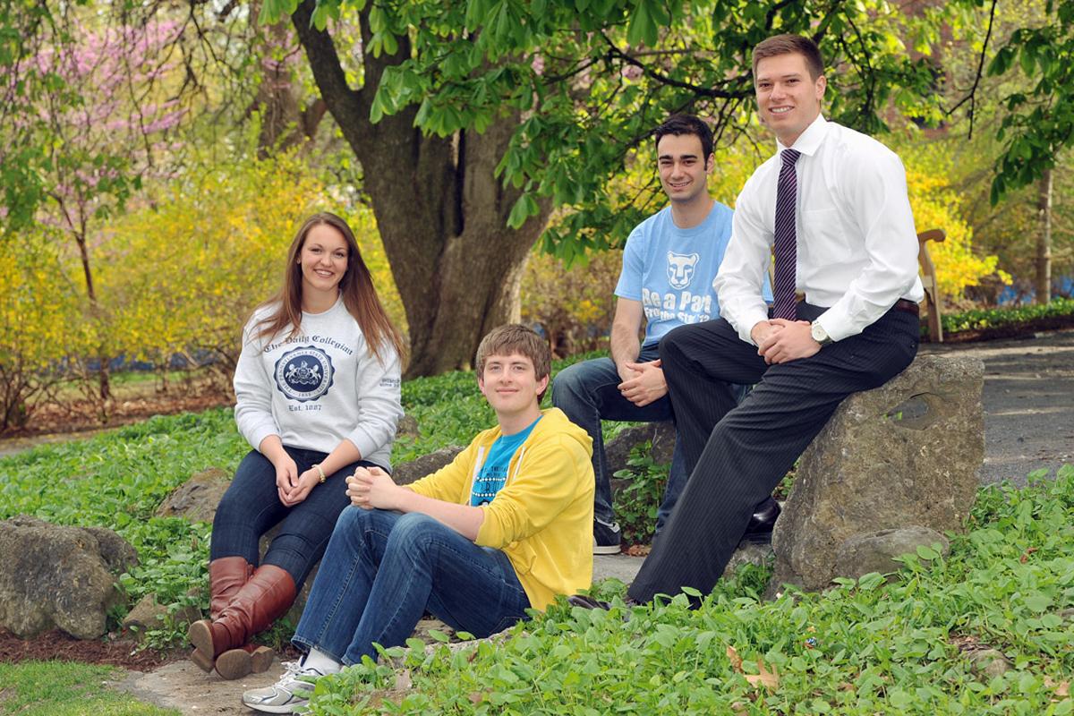 4 students sitting on rocks