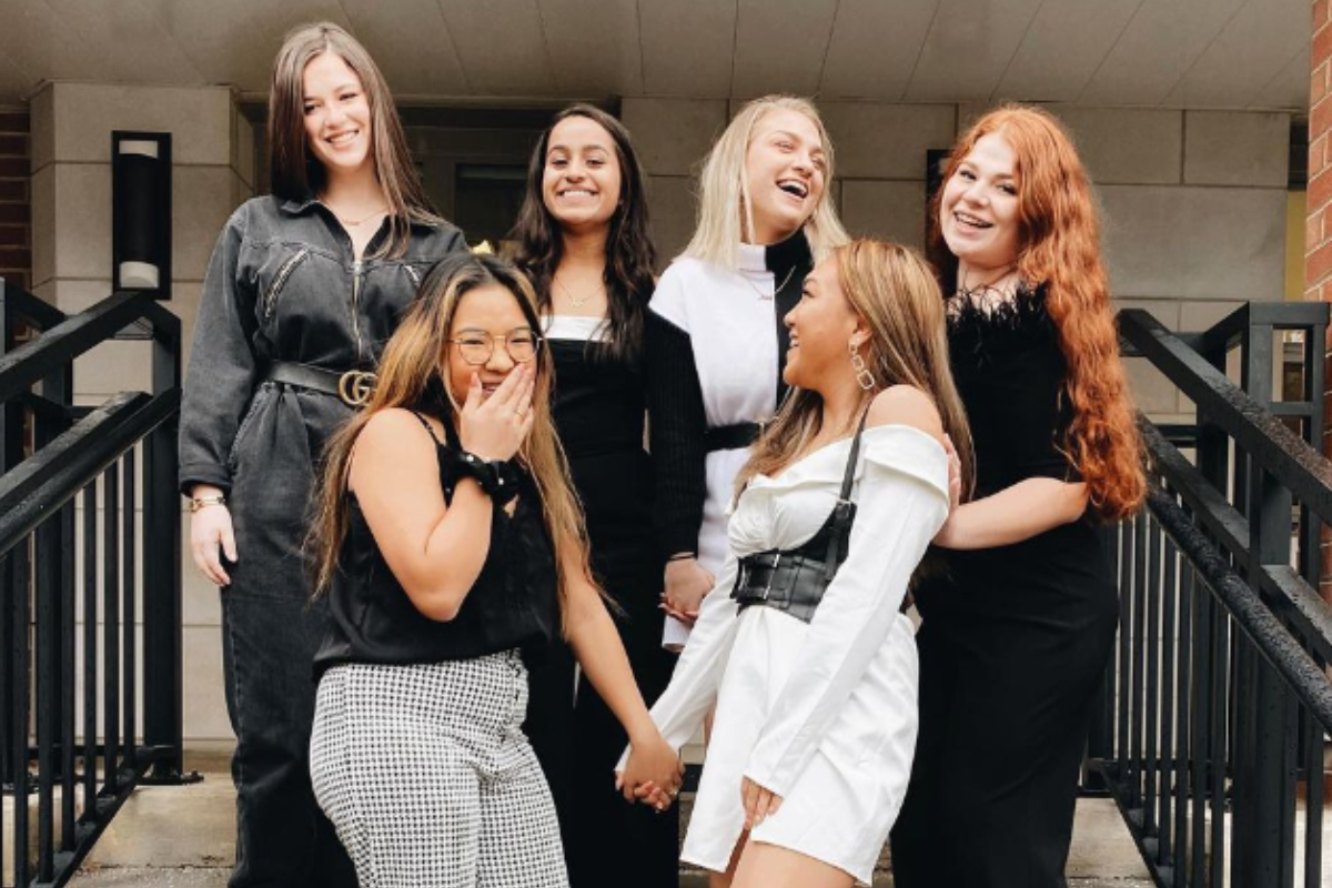 group of women standing on steps, laughing