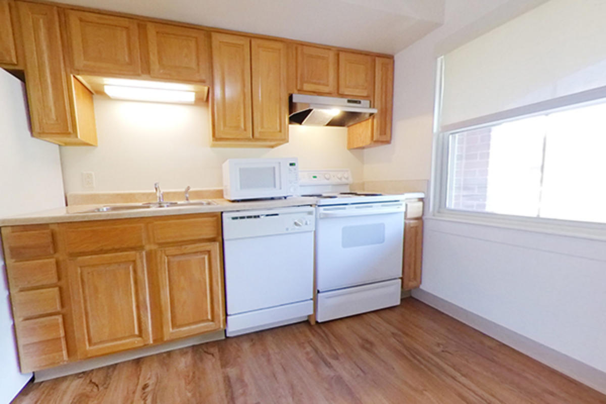 A tidy kitchen with wooden cabinets and appliances.