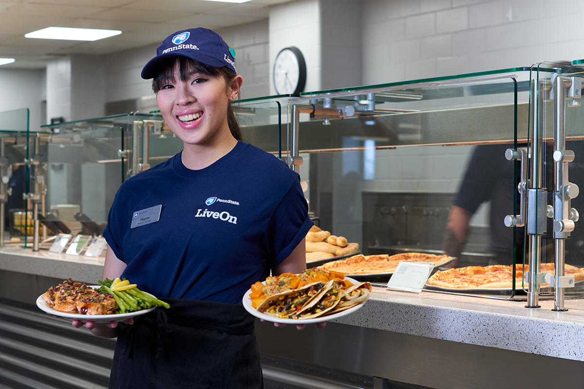 HFS employee holding plates in the dining hall