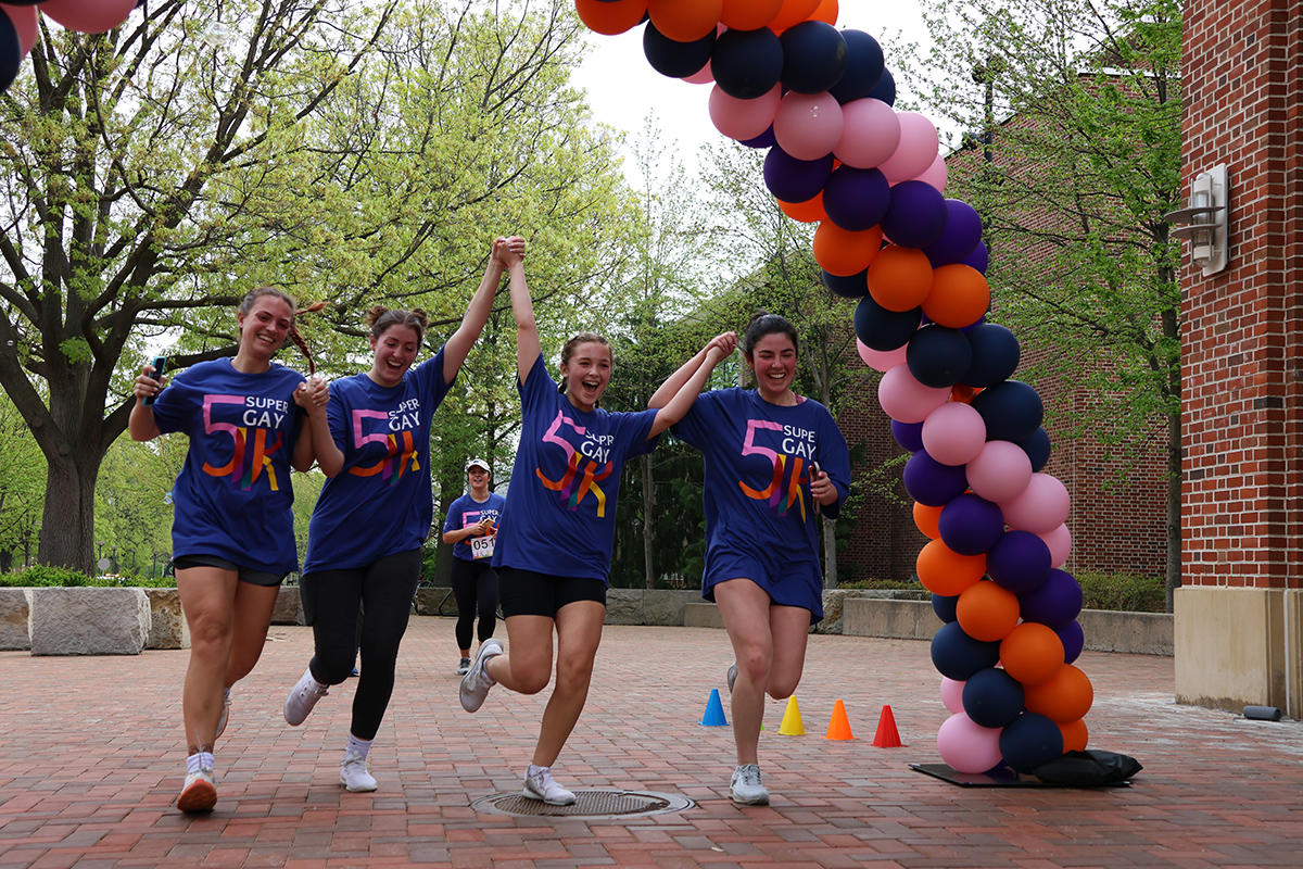 Lavender Lions Students holding hands and crossing the finish line.