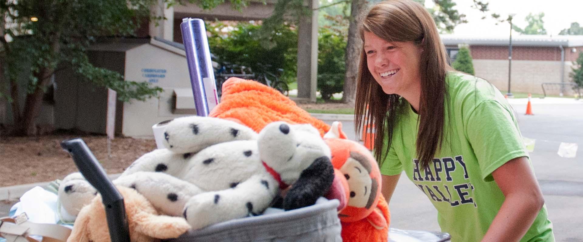 Student moving in her belongs on a cart
