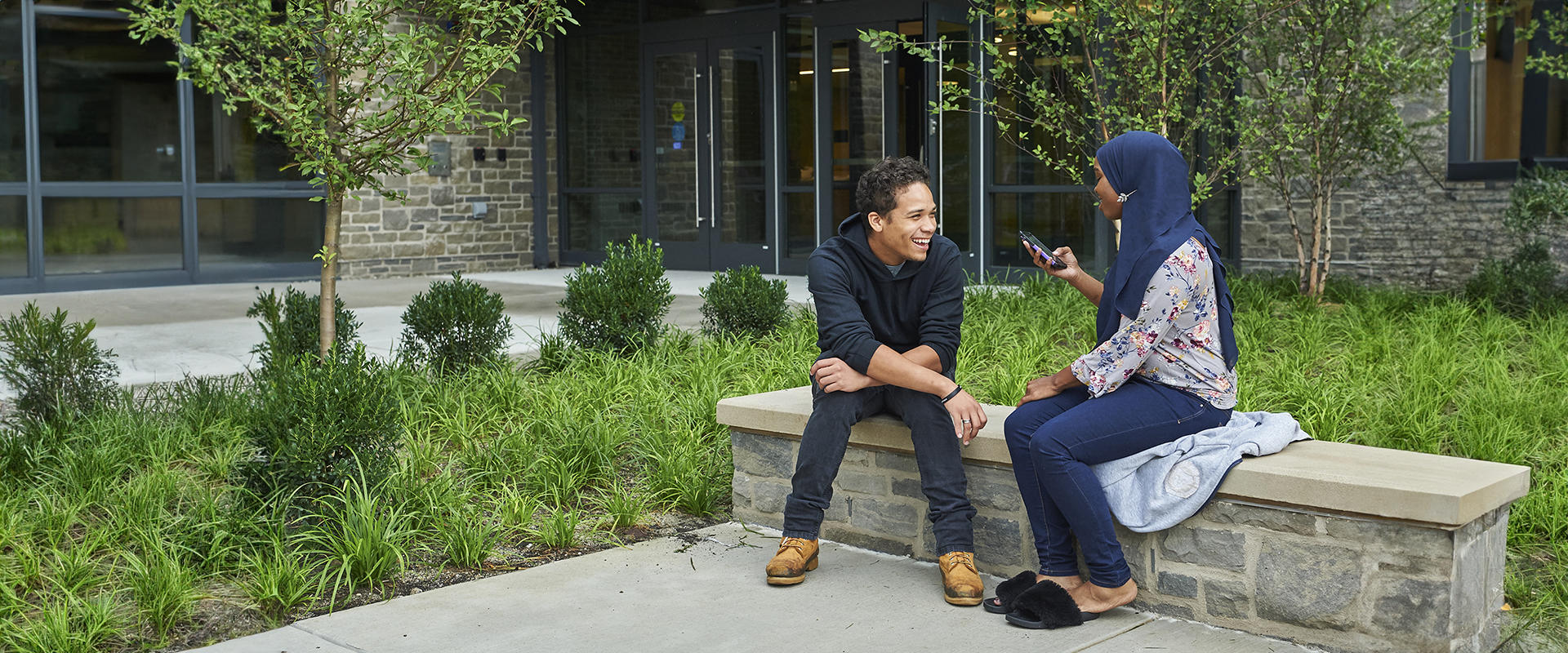 Students visit while seated outdoors.