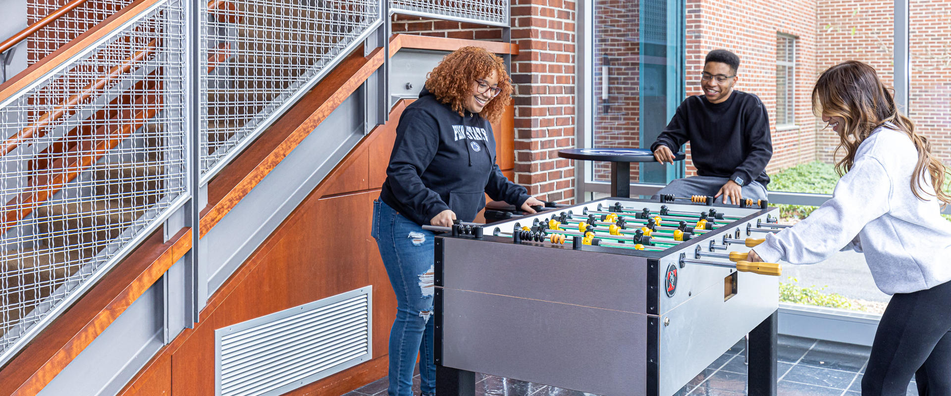 Students play foosball in lounge area