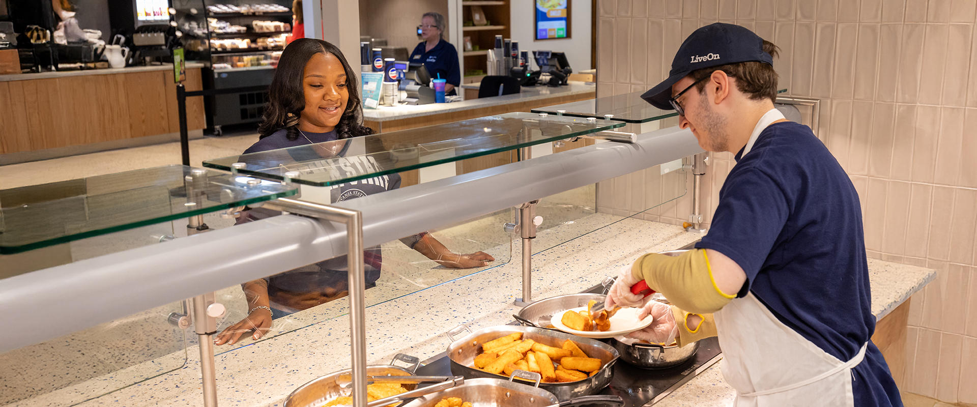 Tully's Employee serves plate of food to student customer