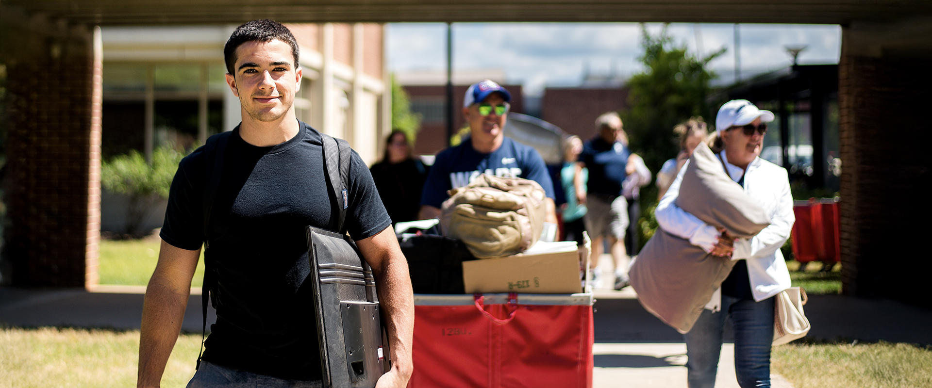 Student and family moving into campus